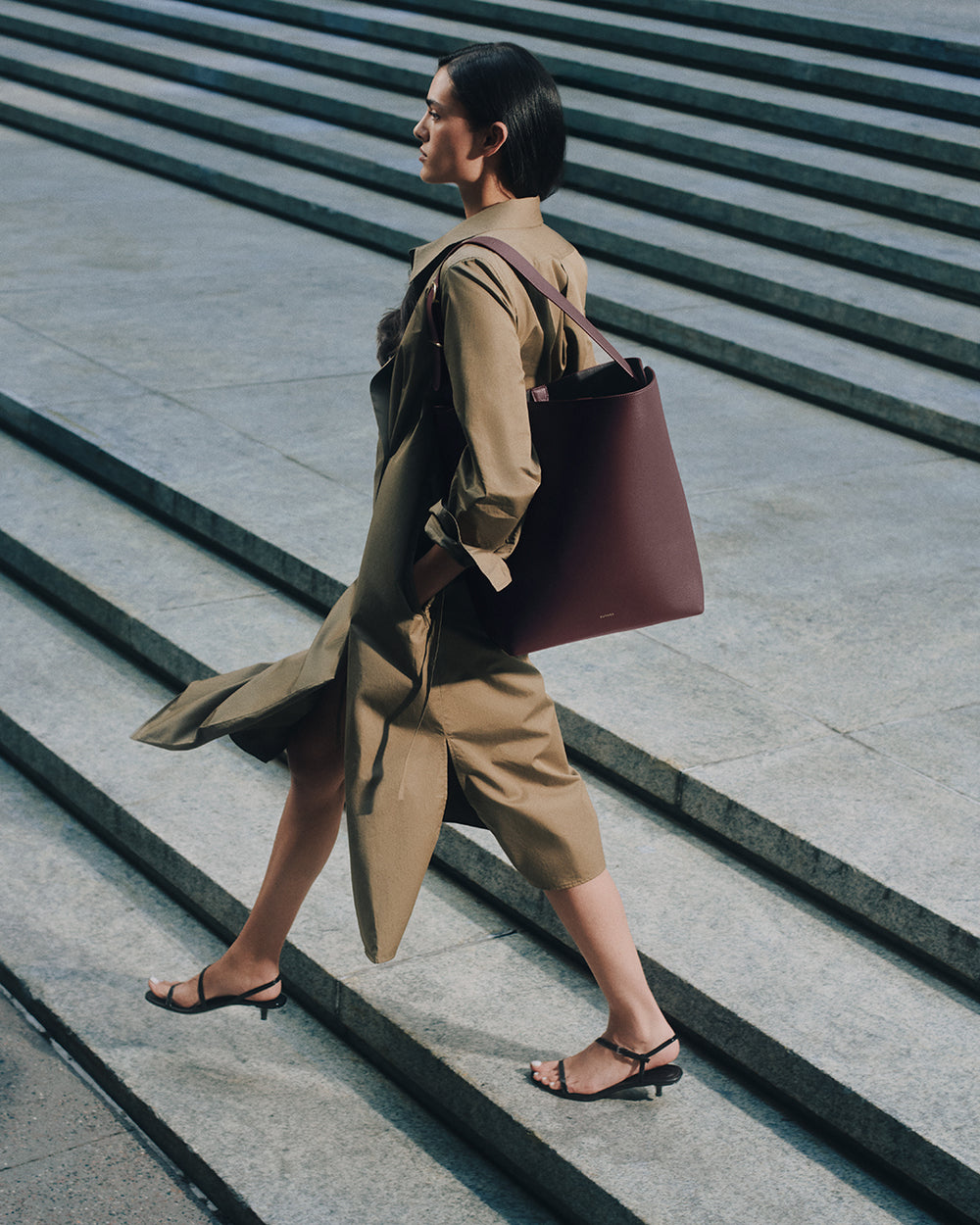 Person walking down steps carrying a large bag