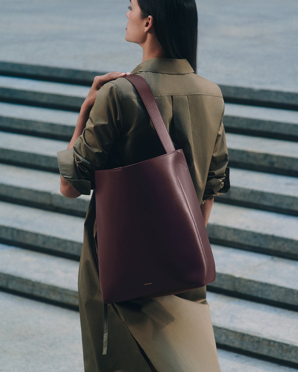 Person with shoulder bag standing on stairs