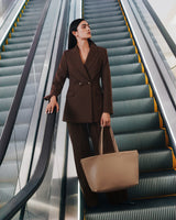 Person in suit holding a large bag on escalator