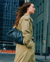 Person walking in the city wearing handbag over shoulder with a metal chain strap