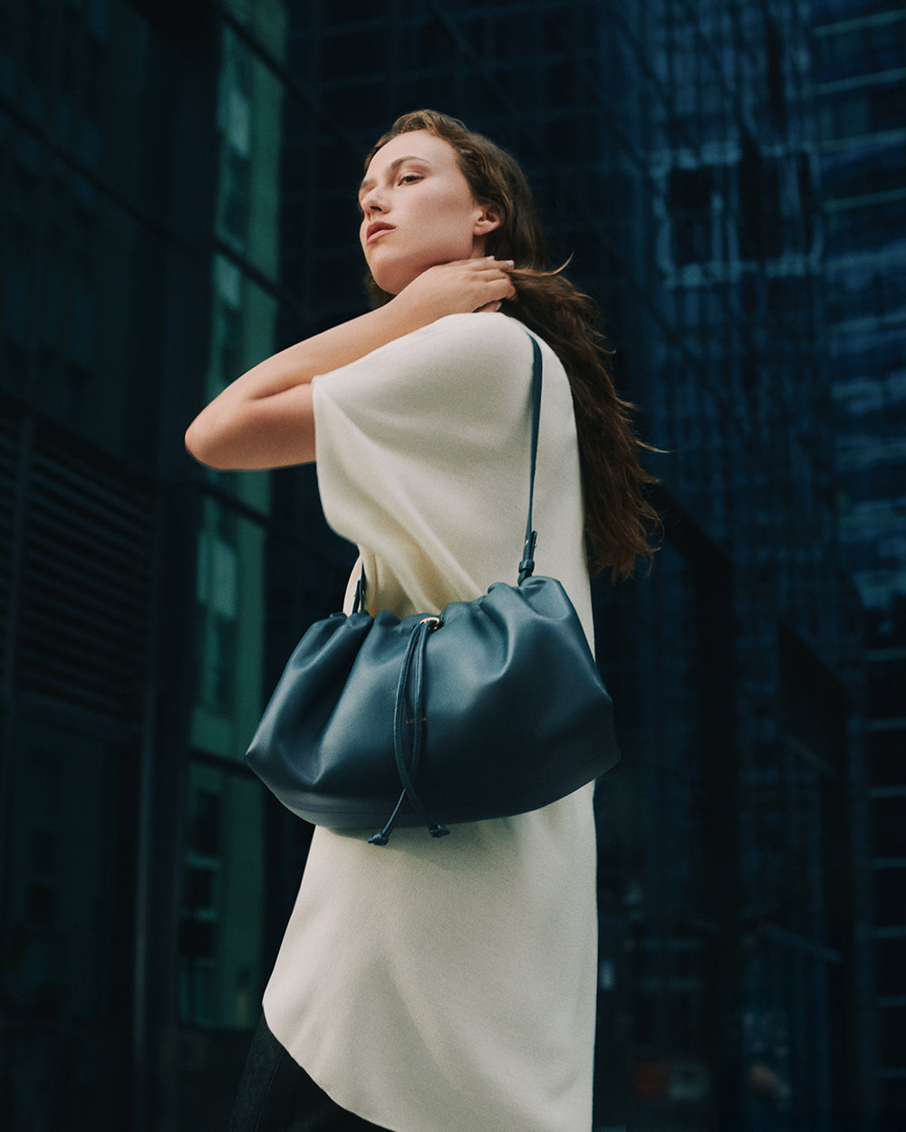 Woman in urban setting carrying a large handbag over her shoulder