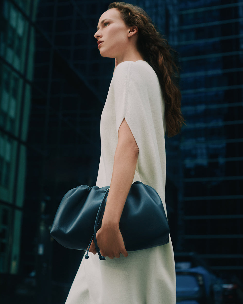 Person holding a large bag, standing in an urban setting
