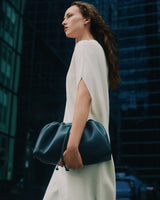 Person holding a large bag, standing in an urban setting