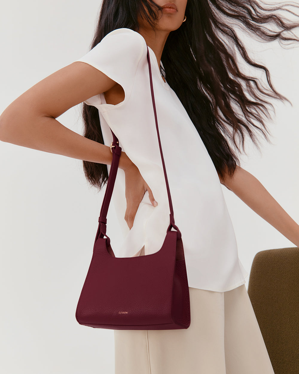 Person holding a shoulder bag while standing.