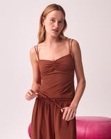Woman standing and holding the waistband of her dress.