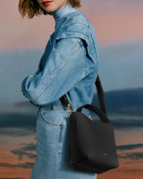 Person wearing a denim jacket with a handbag