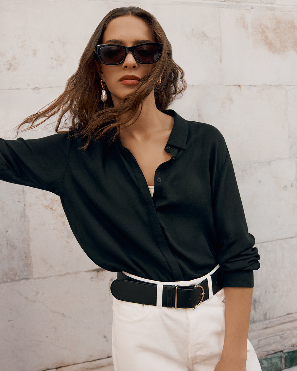 Woman in sunglasses posing with one hand on her hip