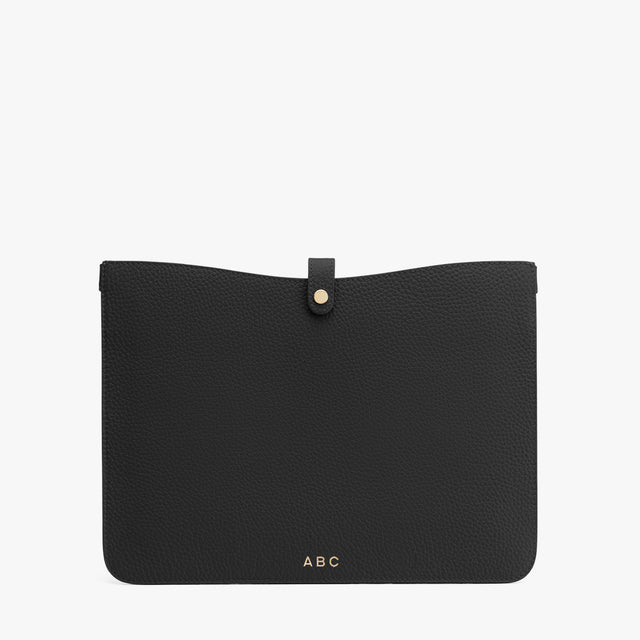 Flat pouch with a tab closure and monogram initials ABC at the bottom.