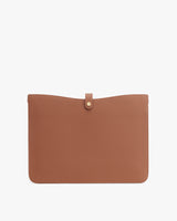 Leather pouch with flap closure on a plain background