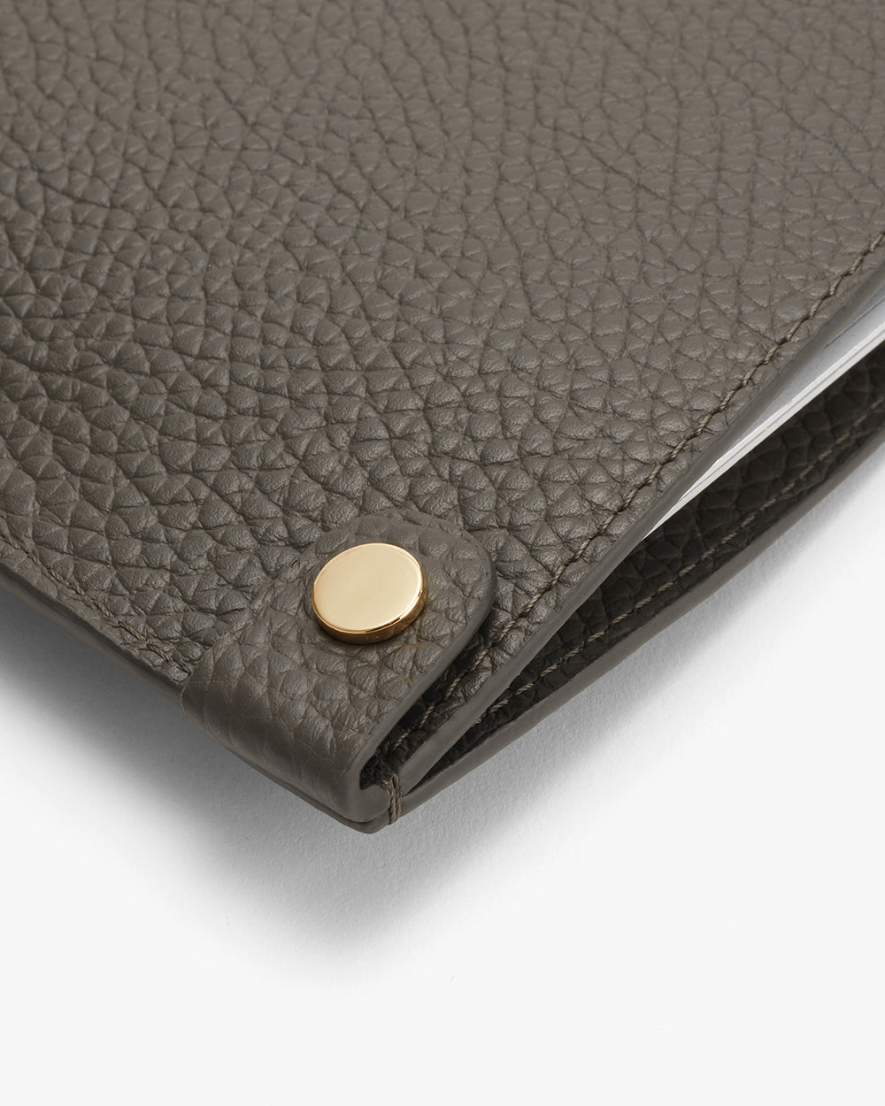 Close-up of a textured wallet with a metallic clasp.