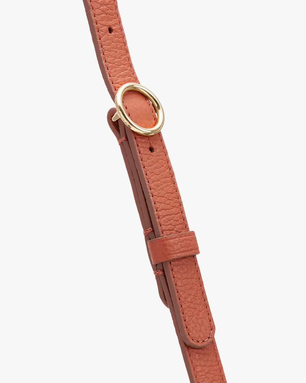 Close-up of a leather strap with a metal buckle and adjustment holes.