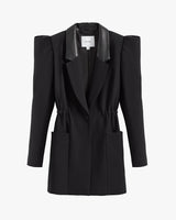 Blazer with exaggerated shoulder pads and lapels, buttoned front, and two pockets.