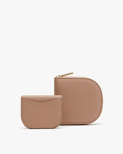 Two small leather wallets, one larger than the other, with zipper closures