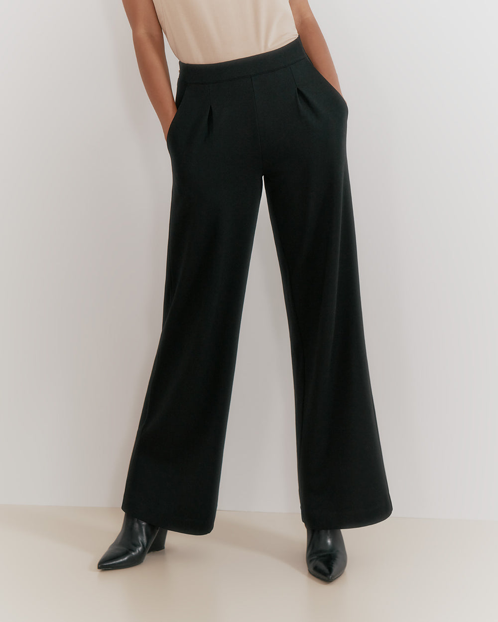 Person standing in wide-legged trousers and shoes.