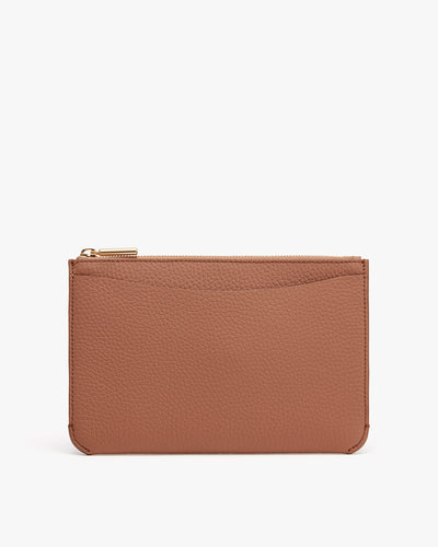 Small textured wallet with zipper on plain background.