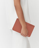 Person holding a small clutch bag.