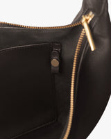 Close-up of inside of a bag with zippered opening and inner pocket.