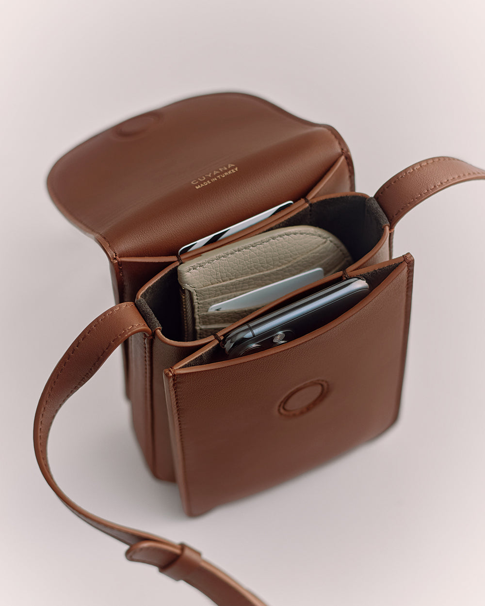 Small open bag with pockets holding a wallet and a phone