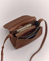 Open handbag showing multiple compartments with a zipper pouch and other items inside.