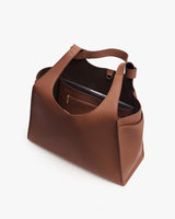 Open handbag with an interior pocket holding a laptop.