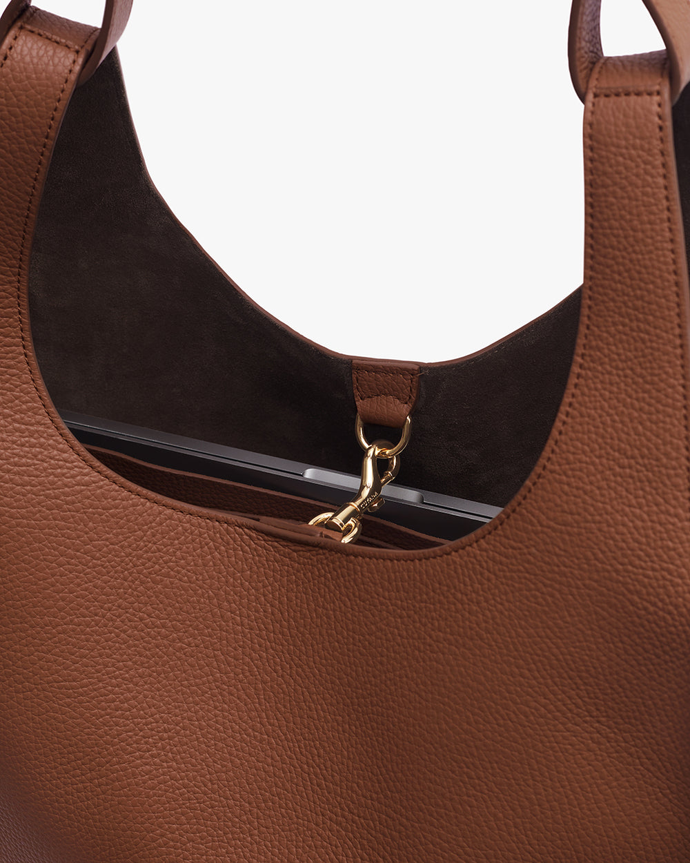 Close-up of an open tote bag with a gold clasp and a visible item inside.