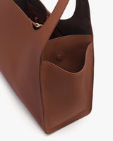 A close-up view of an open tote bag showing its side pocket and interior.