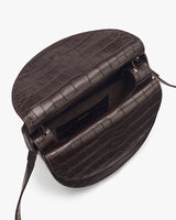 Top view of an open round bag with croc-embossed leather and interior pocket