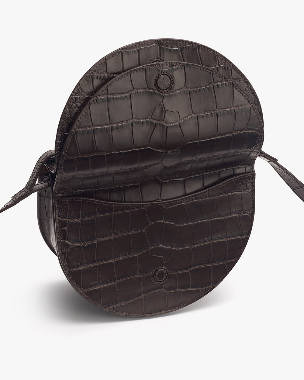 Round bag with croc-embossed leather and a flap closure showing the interior.