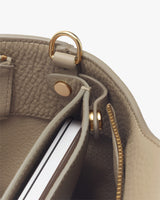 Close-up of an open bag displaying the inside compartments and metal hardware.