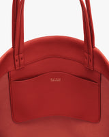 Close-up of a handbag with a front pocket and visible stitching details.