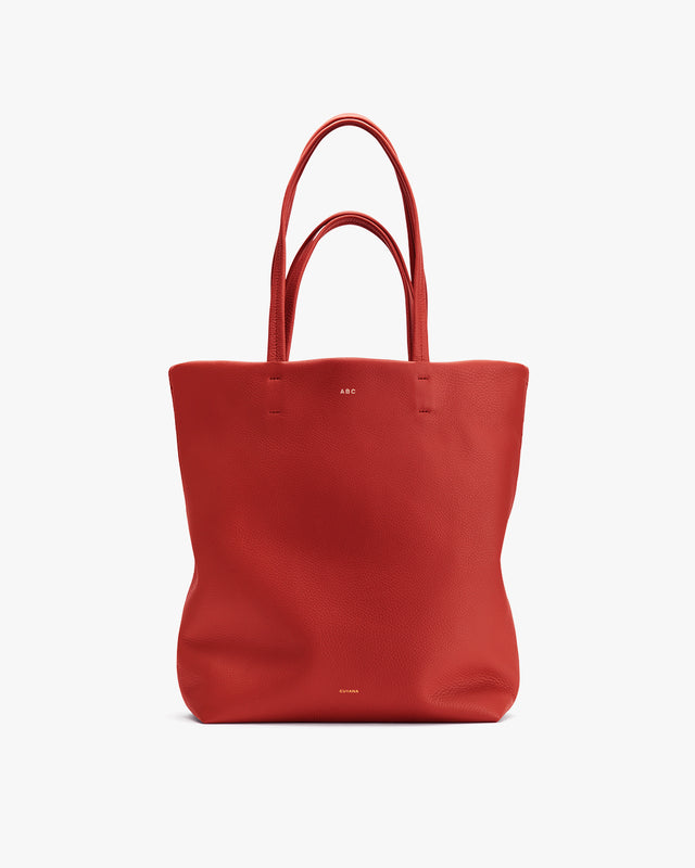 A tote bag with two handles and a small logo at the top center.