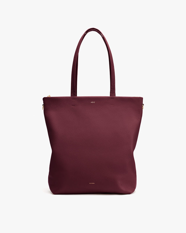 Tote bag with long handles and a small logo on the front.