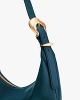 Close-up of a handbag strap with a decorative metal buckle.