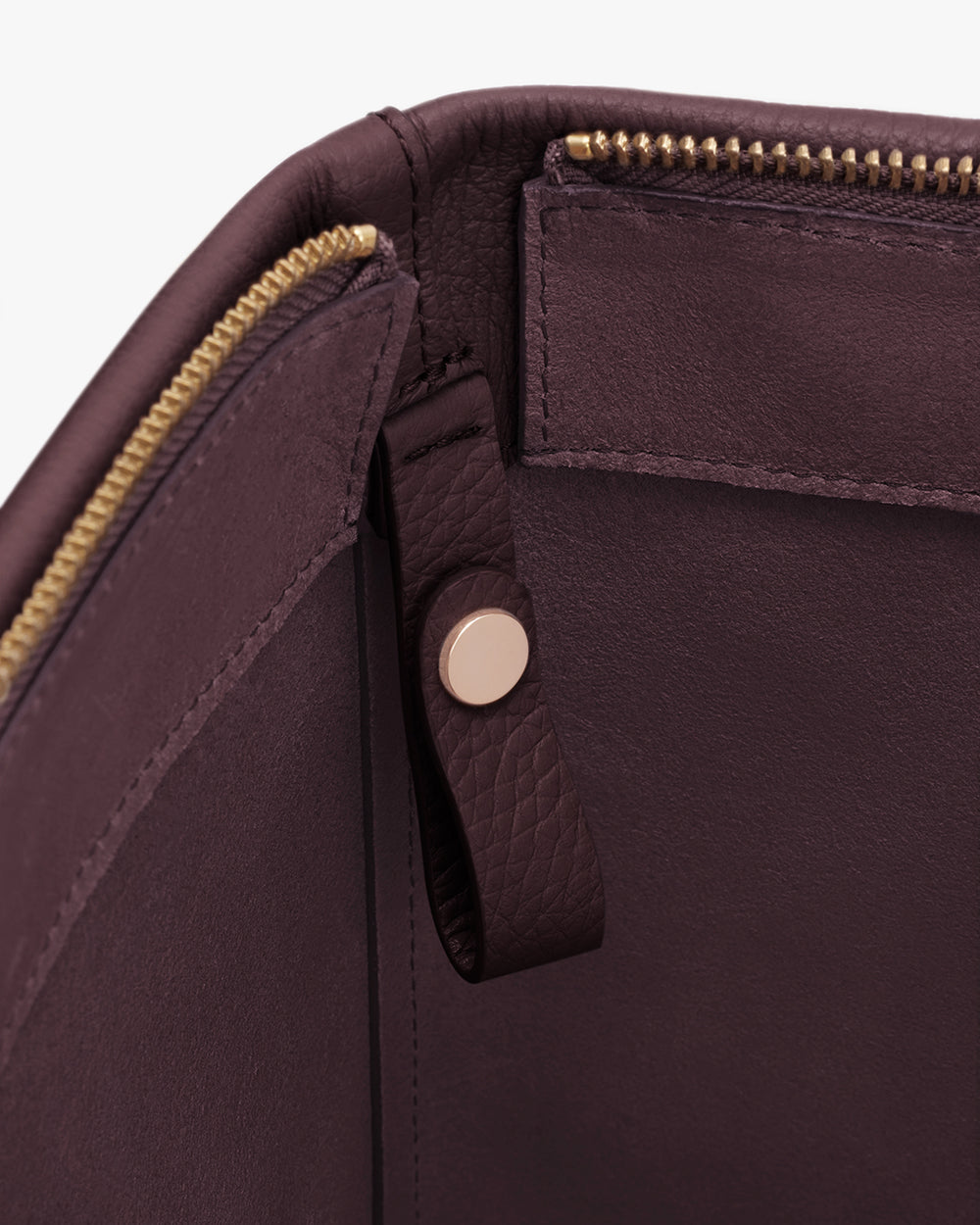 Interior view of a bag with a zipper and leather tab.
