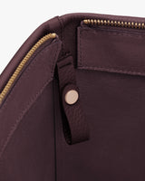 Interior view of a bag with a zipper and leather tab.