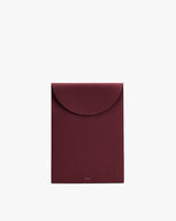 Rectangular leather laptop sleeve bag with a flap closure.