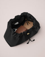 Open drawstring bag with sunglasses, wallet, and keys inside.