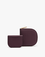 A square zippered wallet next to smaller folded cardholder