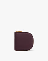 Small zippered wallet standing upright on white background.