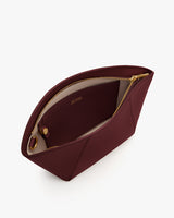 Open zippered pouch with a small interior pocket and brand name inside