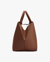 A structured tote bag with two handles and a unique closure.