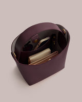 Open handbag with visible contents including a wallet and small pouch.