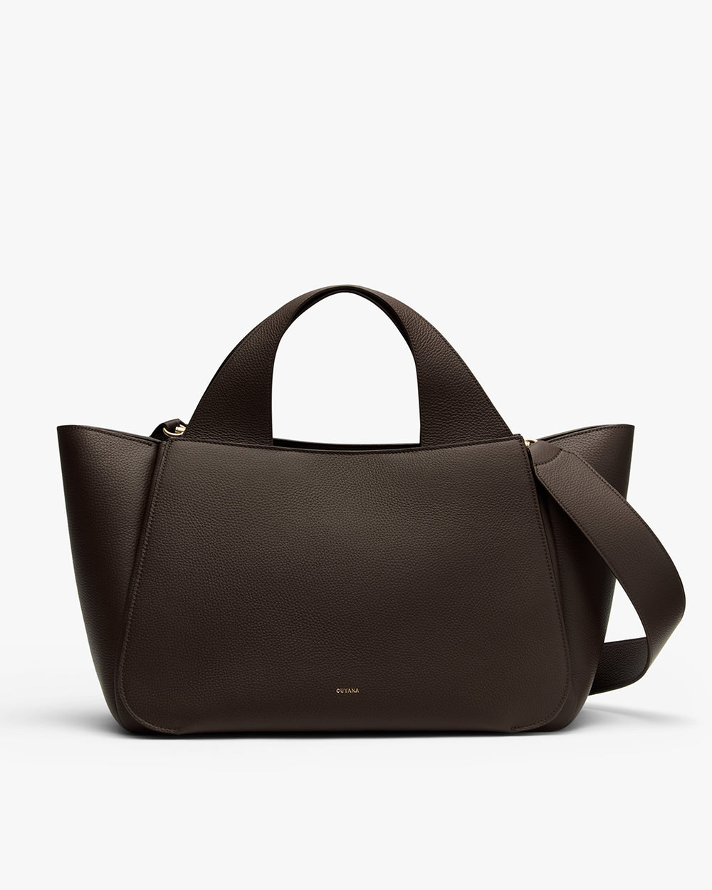 Handbag with two handles and a wide strap lying across it