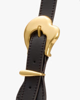 Close-up of a strap with unique gold buckle design.
