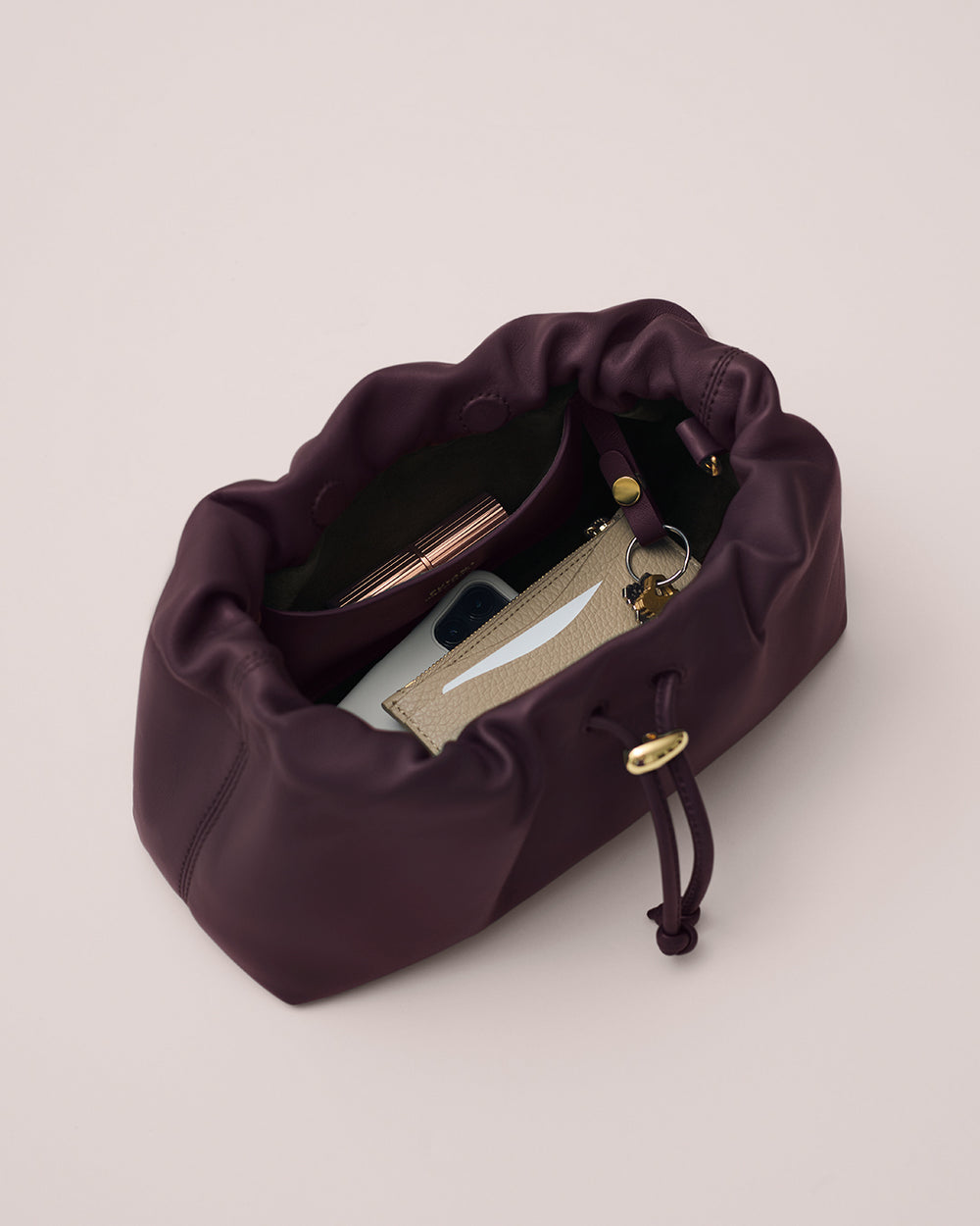 Open handbag containing a phone, wallet, and keychain.