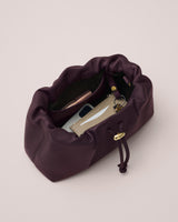 Open handbag containing a phone, wallet, and keychain.