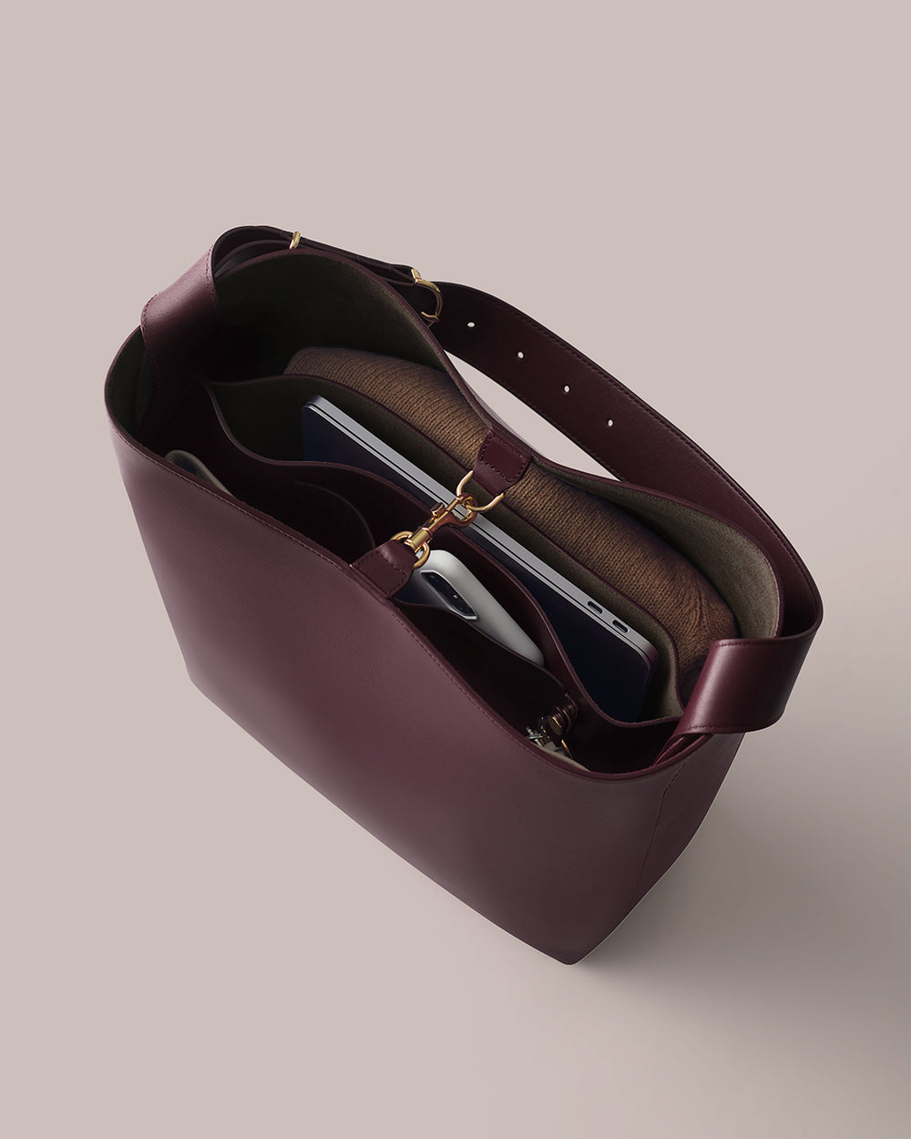 Open tote bag with contents including a laptop, notebook, and a rolled-up item