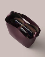 Open tote bag with contents including a laptop, notebook, and a rolled-up item