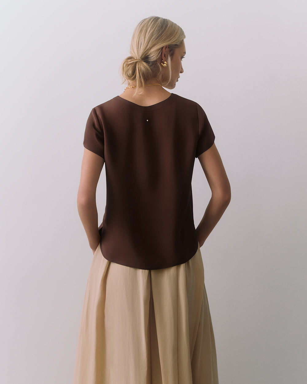 Person facing away wearing a short-sleeve top and flowing skirt