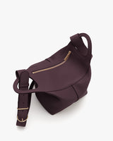 Hexagonal bag with a wide strap and small handle on top.
